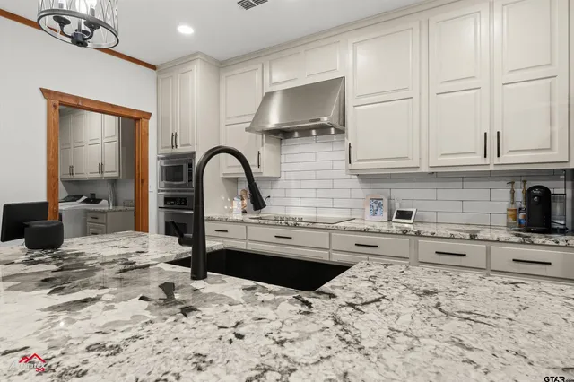 a kitchen with stainless steel appliances kitchen island granite countertop a sink and cabinets