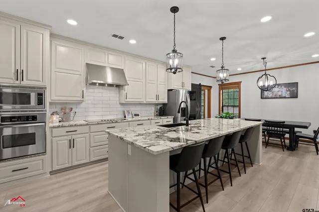 a kitchen with stainless steel appliances kitchen island a cabinets and wooden floor