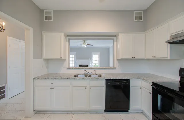 a kitchen with white cabinets and a stove