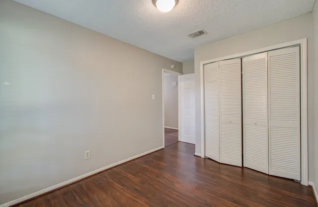 a view of an empty room with wooden floor