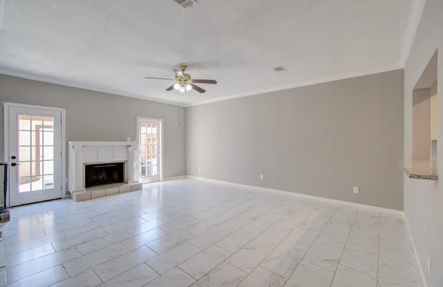 an empty room with windows and fireplace