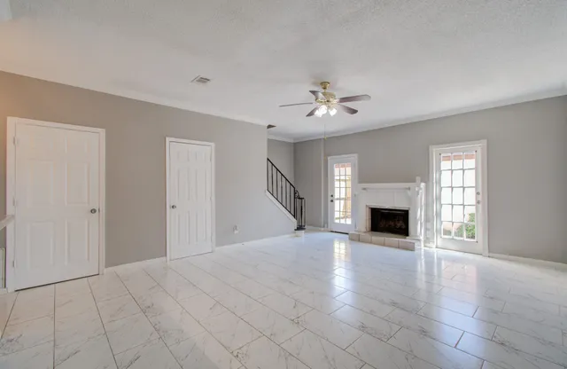 a view of empty room with fireplace and wooden floor