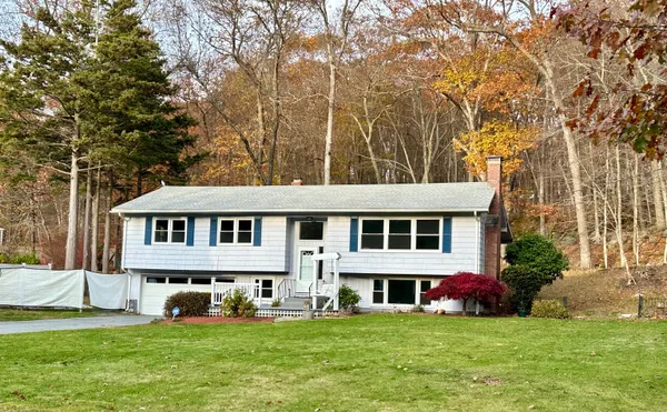 a view of a house with a big yard and large trees