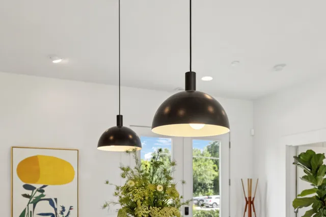 a patio with a table and chairs and potted plants