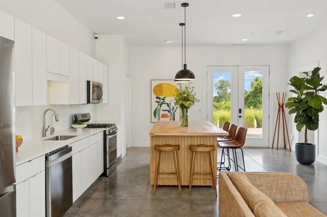 a kitchen with stainless steel appliances a stove a sink a refrigerator and cabinets