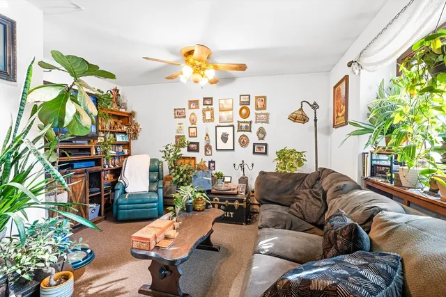 a living room with patio furniture and a potted plant