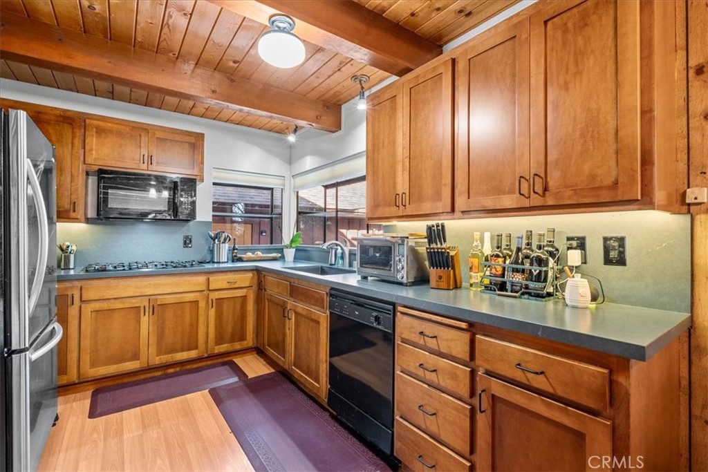 1631 Linnet Road Wrightwood, CA 92397 - Photo 14 of 42 a kitchen with stainless steel appliances granite countertop wooden cabinets a sink and dishwasher