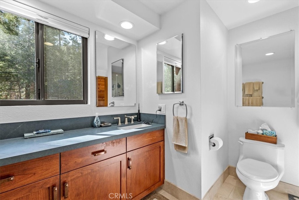 1631 Linnet Road Wrightwood, CA 92397 - Photo 30 of 42 a bathroom with a granite countertop toilet sink and mirror