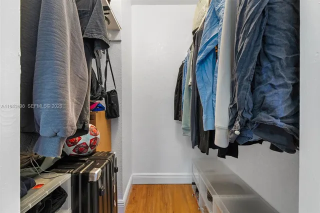 a view of walk in closet with clothes and shoes