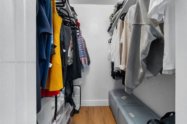 a view of walk in closet with clothes and shoes