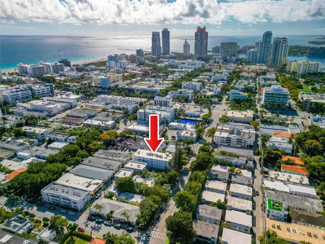 an aerial view of a city with lots of residential buildings ocean and mountain view in back