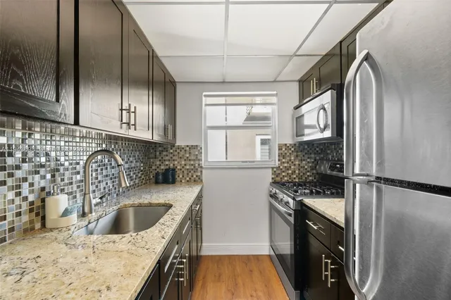 a kitchen with a refrigerator sink and stove