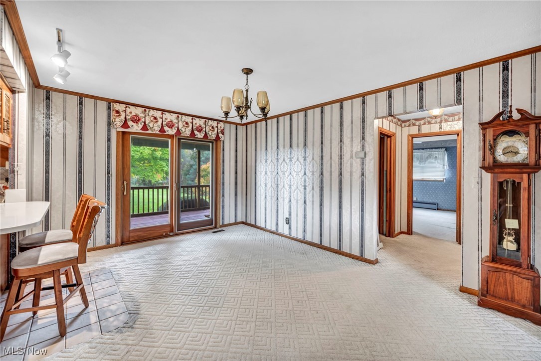 9184 Zimmerman Road Homerville, OH 44235 - Photo 24 of 50 Dining room featuring baseboard heating, a chandelier, light carpet, and crown molding