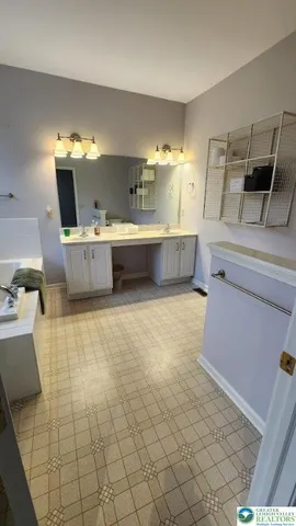 a bathroom with a tub sink and mirror