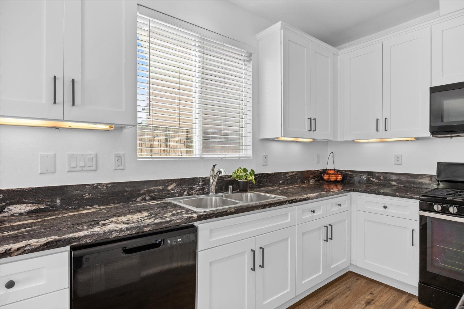 5407 Mensen Drive Bakersfield, CA 93313 - Photo 11 of 36 a kitchen with granite countertop white cabinets and a sink