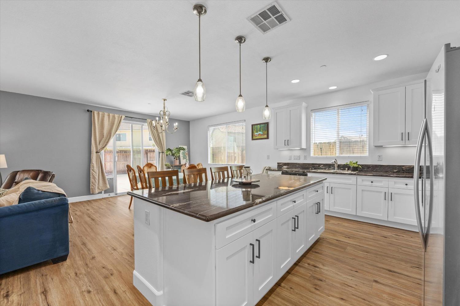 5407 Mensen Drive Bakersfield, CA 93313 - Photo 15 of 36 a large kitchen with kitchen island a large counter top space a sink stainless steel appliances and cabinets