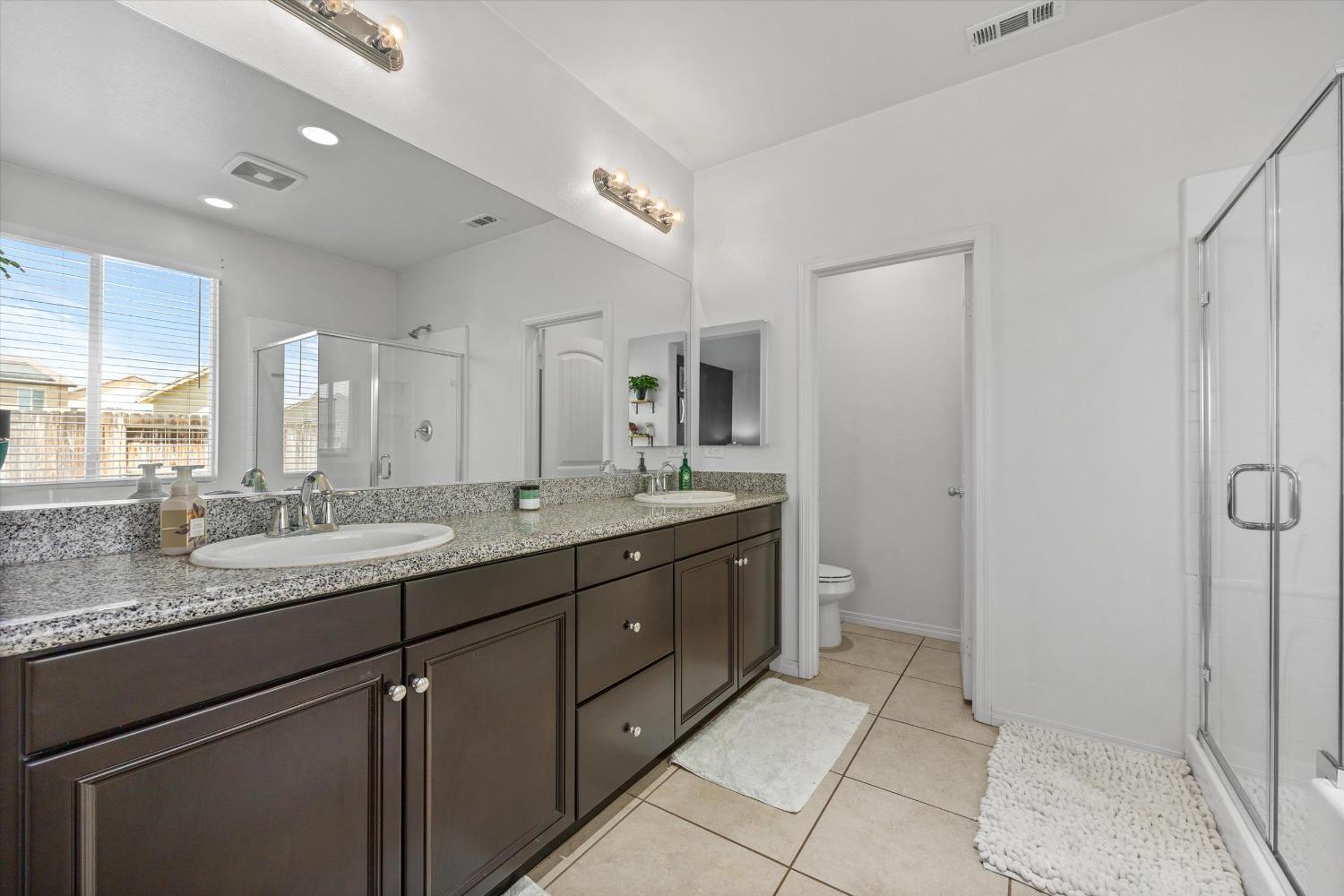 5407 Mensen Drive Bakersfield, CA 93313 - Photo 19 of 36 a bathroom with a granite countertop sink and a mirror
