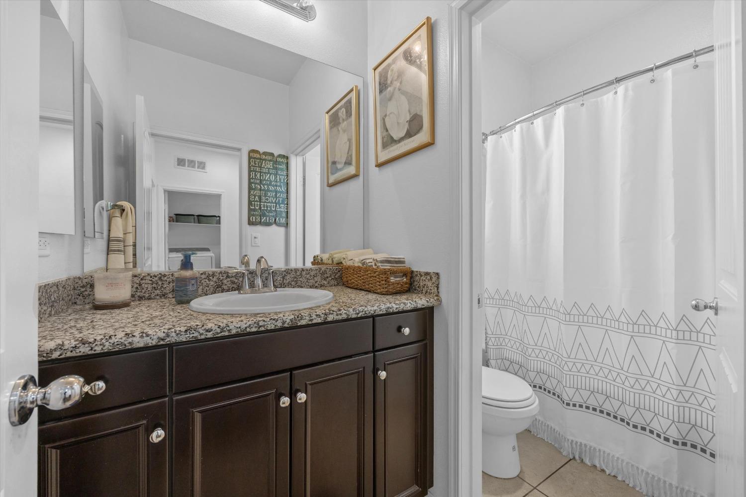 5407 Mensen Drive Bakersfield, CA 93313 - Photo 25 of 36 a bathroom with a granite countertop sink a toilet and a mirror
