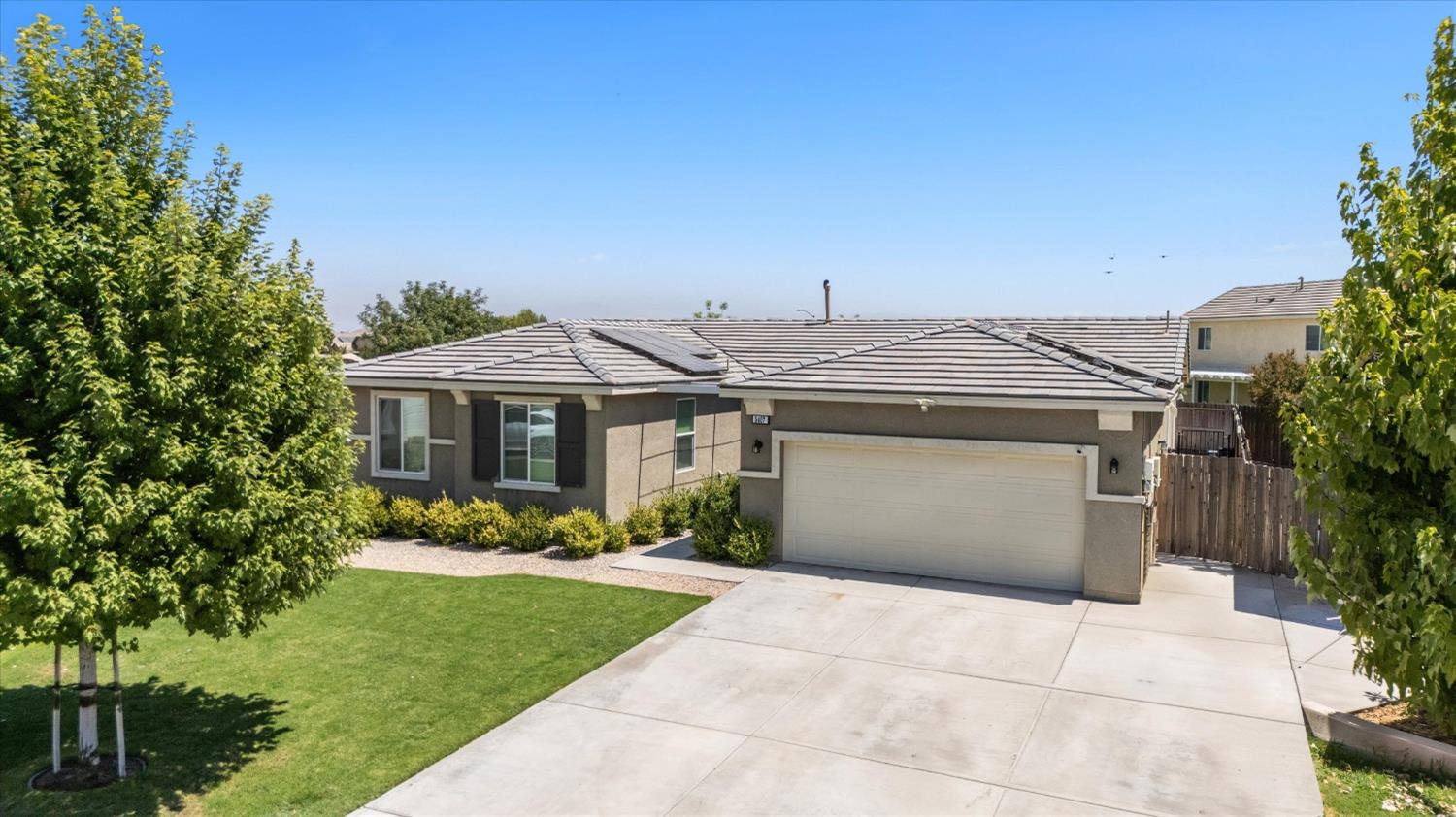 5407 Mensen Drive Bakersfield, CA 93313 - Photo 3 of 36 a front view of a house with a garden and trees