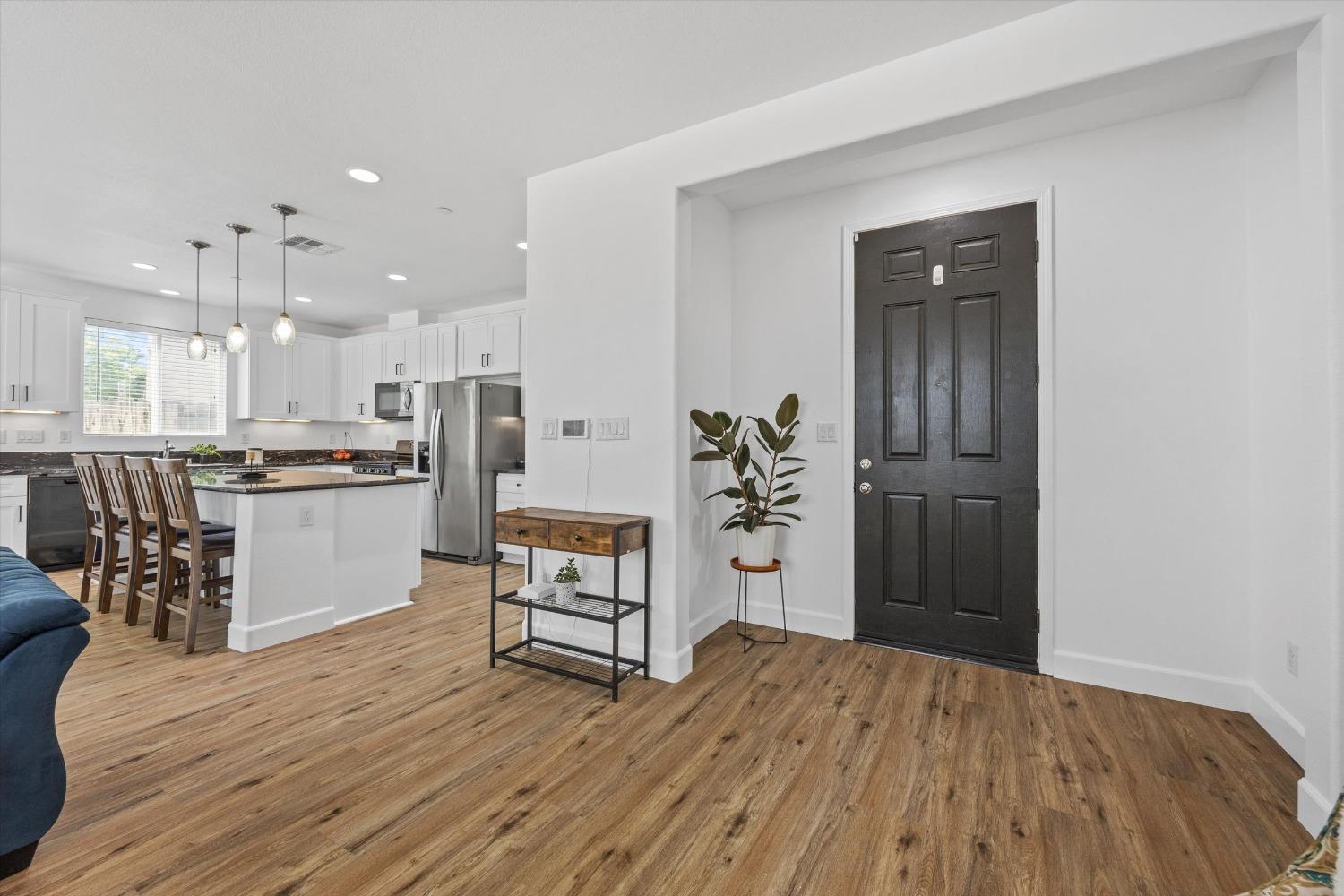 5407 Mensen Drive Bakersfield, CA 93313 - Photo 8 of 36 a kitchen with stainless steel appliances kitchen island granite countertop a refrigerator and a wooden floor