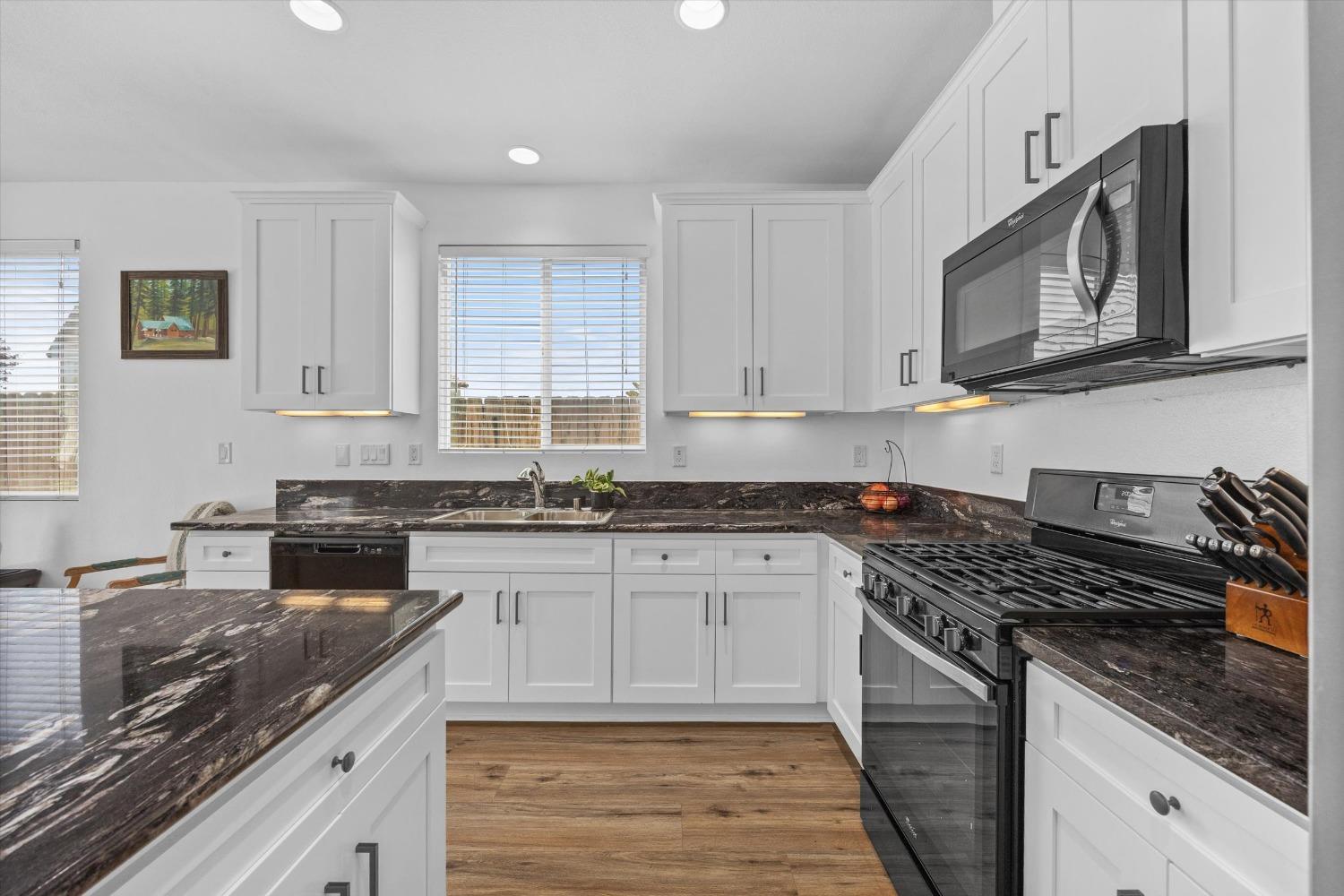 5407 Mensen Drive Bakersfield, CA 93313 - Photo 9 of 36 a kitchen with stainless steel appliances granite countertop a stove a sink and a microwave