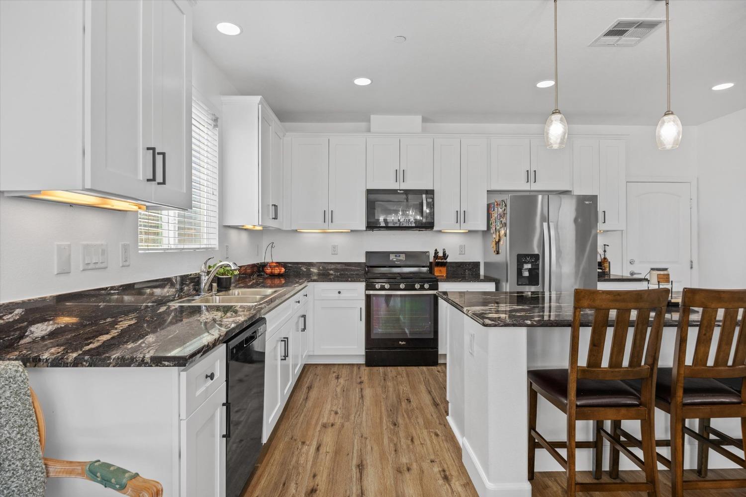5407 Mensen Drive Bakersfield, CA 93313 - Photo 10 of 36 a kitchen with granite countertop a sink a counter top space stainless steel appliances and cabinets