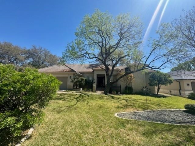407 Quick Silver Horseshoe Bay, TX 78657 - Photo 2 of 31 a view of a yard with a house and large trees