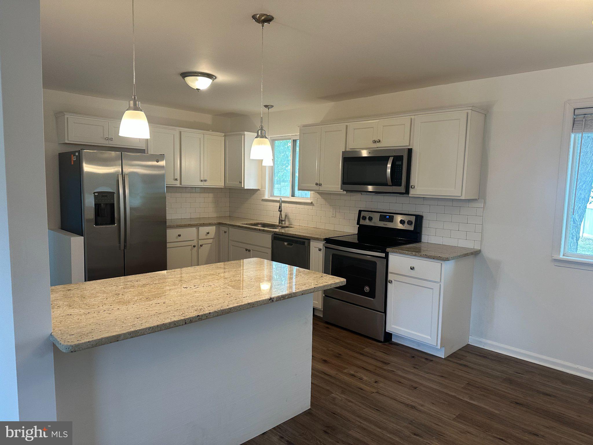 6 Travertine Way Newark, DE 19702 - Photo 4 of 22 a kitchen with stainless steel appliances kitchen island granite countertop a refrigerator stove top oven and sink
