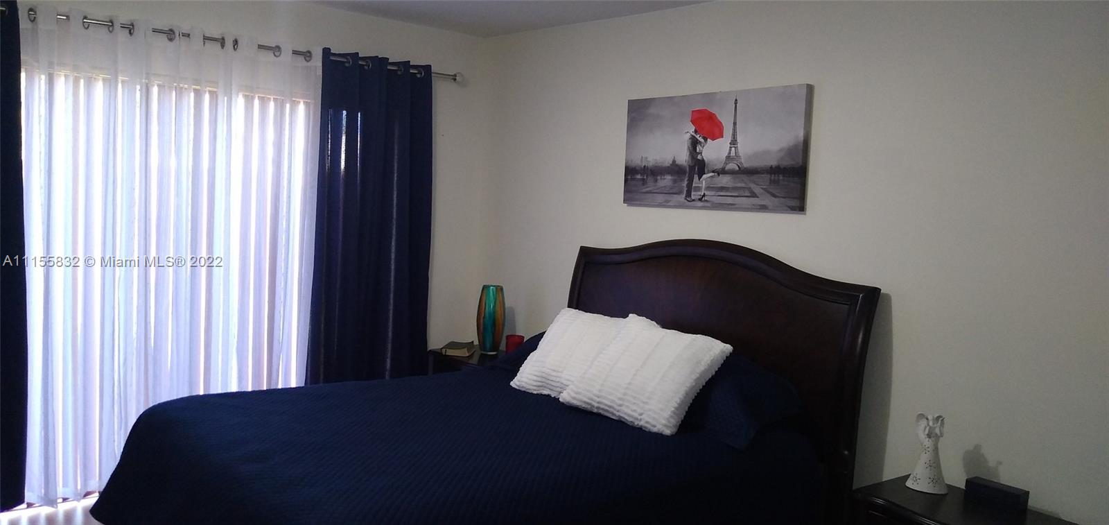 Lakes on the Green Hialeah, FL 33018 - Photo 13 of 24 a bedroom with a bed and a painting on the wall