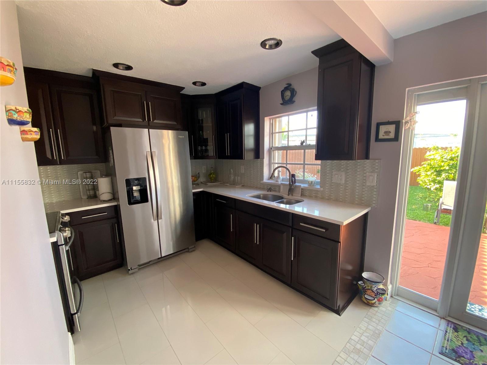 Lakes on the Green Hialeah, FL 33018 - Photo 9 of 24 a kitchen with stainless steel appliances granite countertop a refrigerator a sink a stove and island