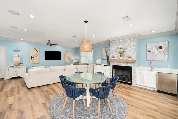 a kitchen with stainless steel appliances kitchen island granite countertop a dining table chairs and white cabinets