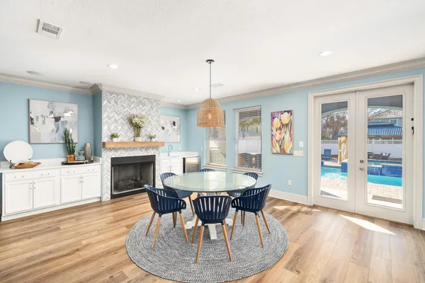 a kitchen with stainless steel appliances kitchen island granite countertop a refrigerator a stove top oven and a dining table with wooden floor