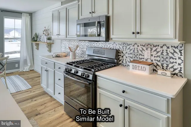 a kitchen with granite countertop a stove sink and cabinets