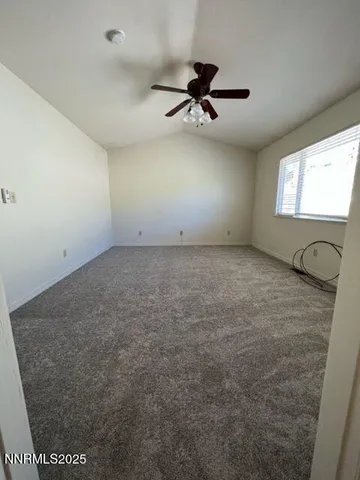 a view of a livingroom with a ceiling fan and window