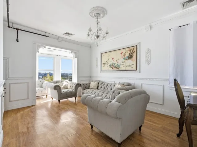 a living room with furniture and a chandelier