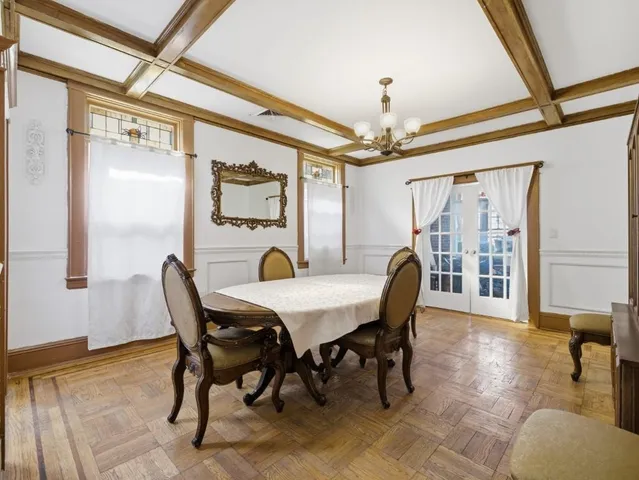 a dining room with furniture a chandelier and wooden floor