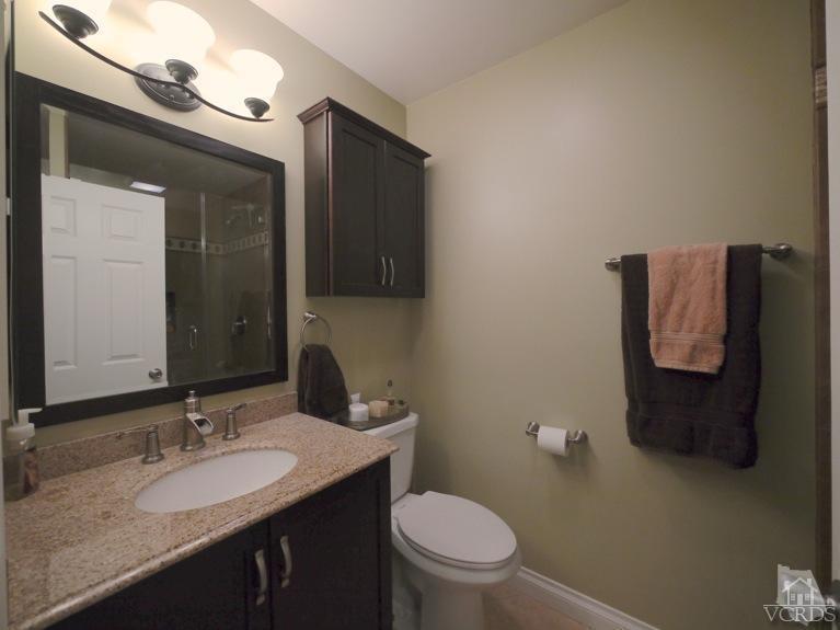 13421 Laurelhurst Road Moorpark, CA 93021 - Photo 21 of 28 a bathroom with a granite countertop sink and a toilet