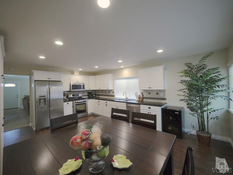 13421 Laurelhurst Road Moorpark, CA 93021 - Photo 5 of 28 a kitchen with stainless steel appliances a dining table chairs stove and kitchen view