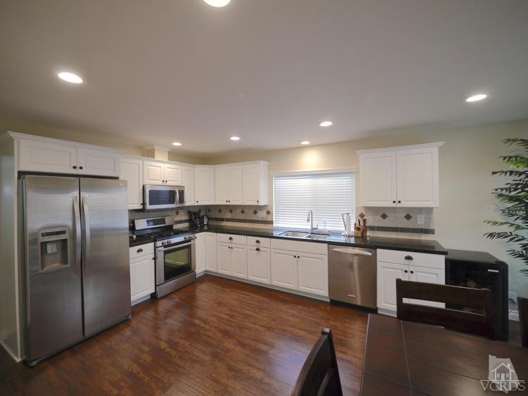 13421 Laurelhurst Road Moorpark, CA 93021 - Photo 6 of 28 a kitchen with stainless steel appliances granite countertop a refrigerator and a stove top oven