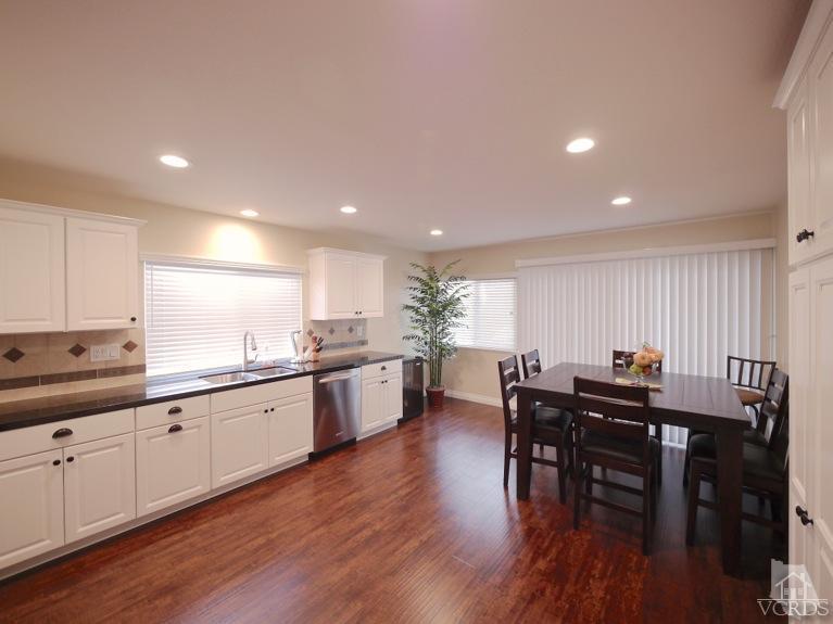 13421 Laurelhurst Road Moorpark, CA 93021 - Photo 7 of 28 a kitchen with stainless steel appliances granite countertop wooden floor a dining table and chairs
