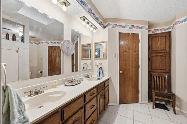 a bath room with a sink double vanity and a mirror