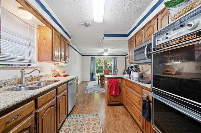 a kitchen with stove cabinets and fan