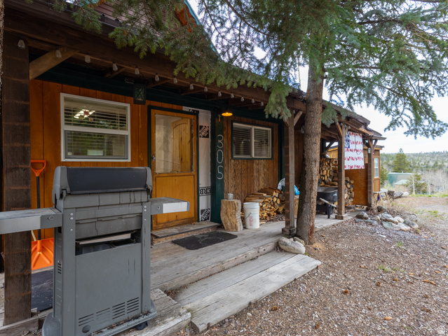 5082 Pine Crest Road Evanston, UT 82930 - Photo 4 of 25 Rustic wood-sided exterior featuring a covered porch, exposed wood beams, and a natural wood entry door