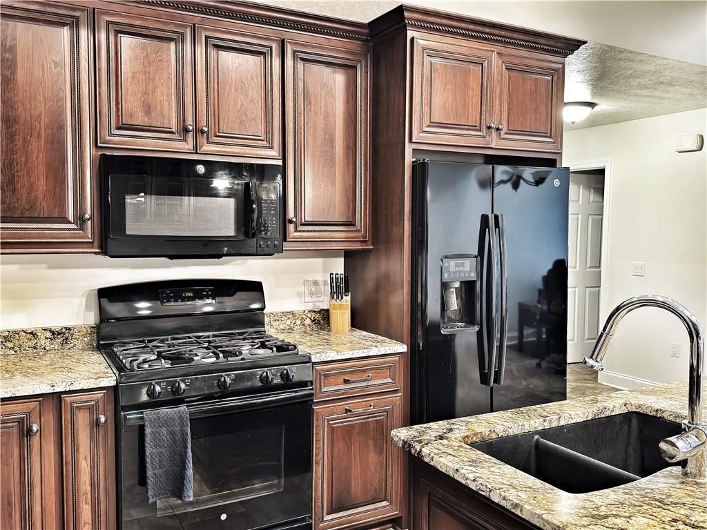 67 Nicholas Drive Beaver, PA 15009 - Photo 10 of 27 a kitchen with granite countertop a stove and a refrigerator