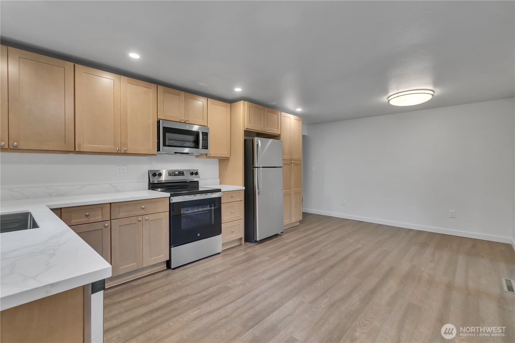 2728 Natalie Lane Steilacoom, WA 98388 - Photo 7 of 23 a kitchen with a sink a microwave a refrigerator and cabinets