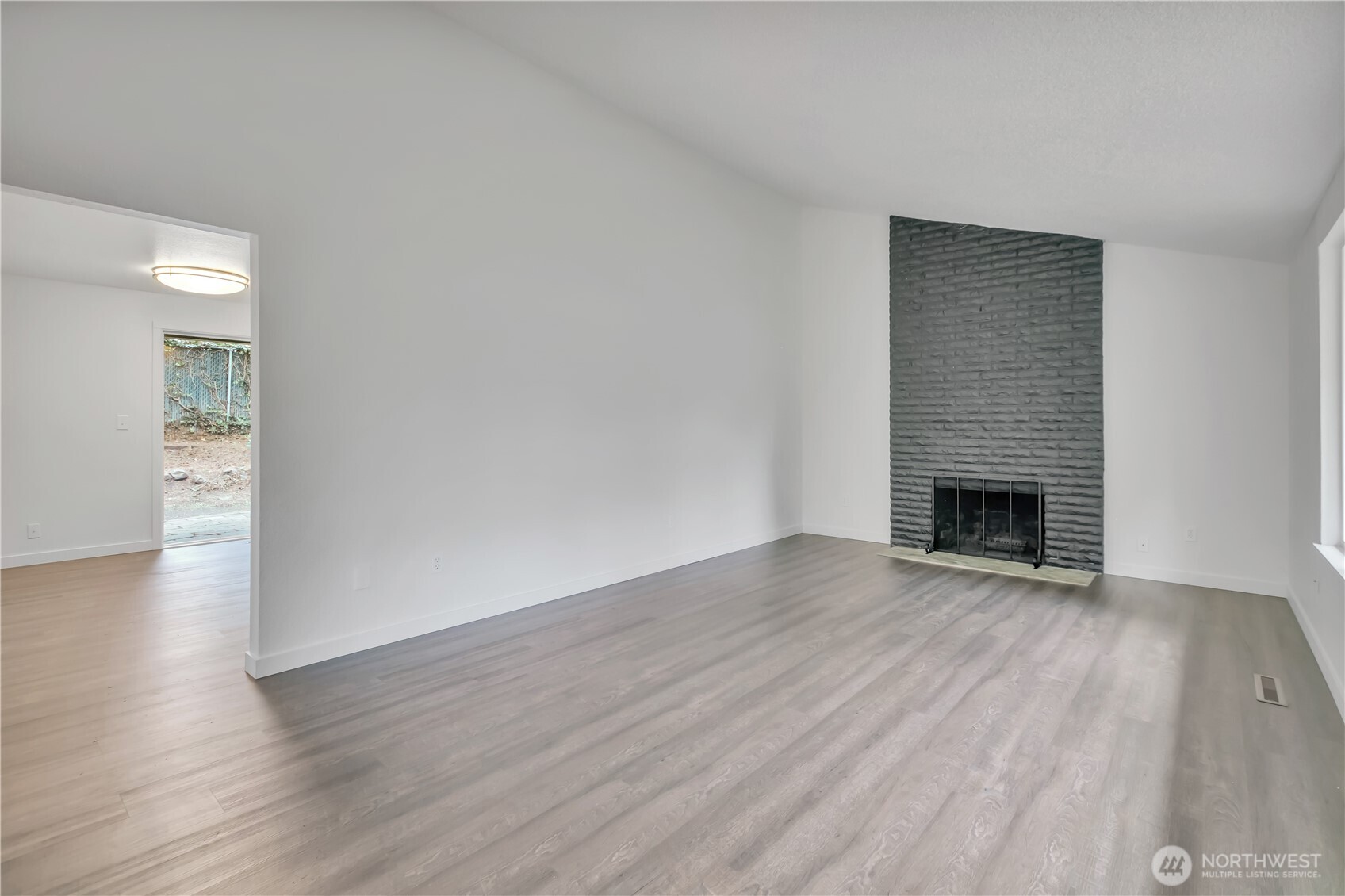 2728 Natalie Lane Steilacoom, WA 98388 - Photo 10 of 23 a view of an empty room with wooden floor fireplace and a window