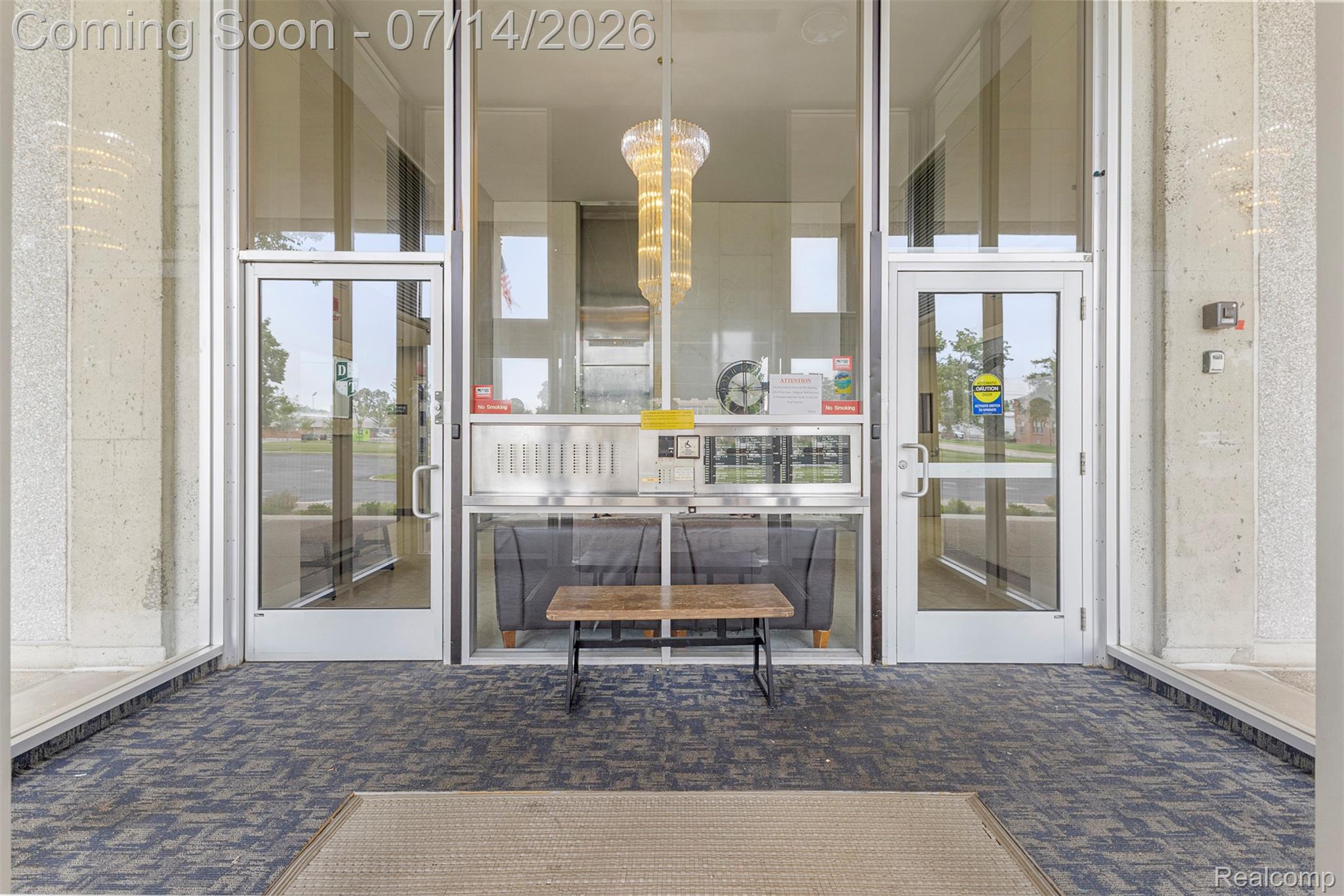 22700 Garrison Street, Unit 707 Dearborn, MI 48124 - Photo 20 of 22 Entryway featuring a patterned carpet, full-light glass doors, and a decorative overhead light fixture