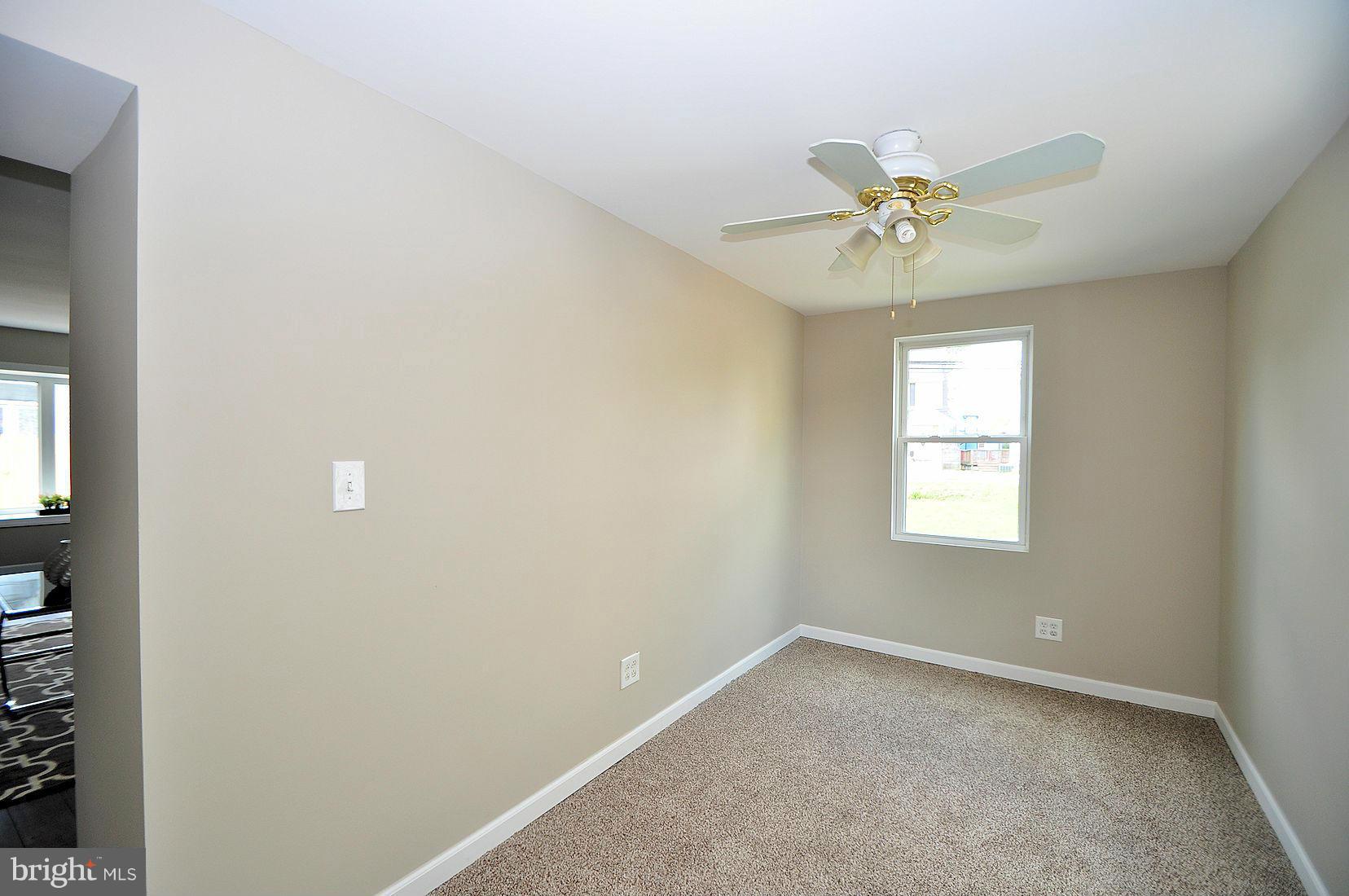 3811 Annapolis Road Baltimore, MD 21227 - Photo 22 of 22 an empty room with a window and a fan