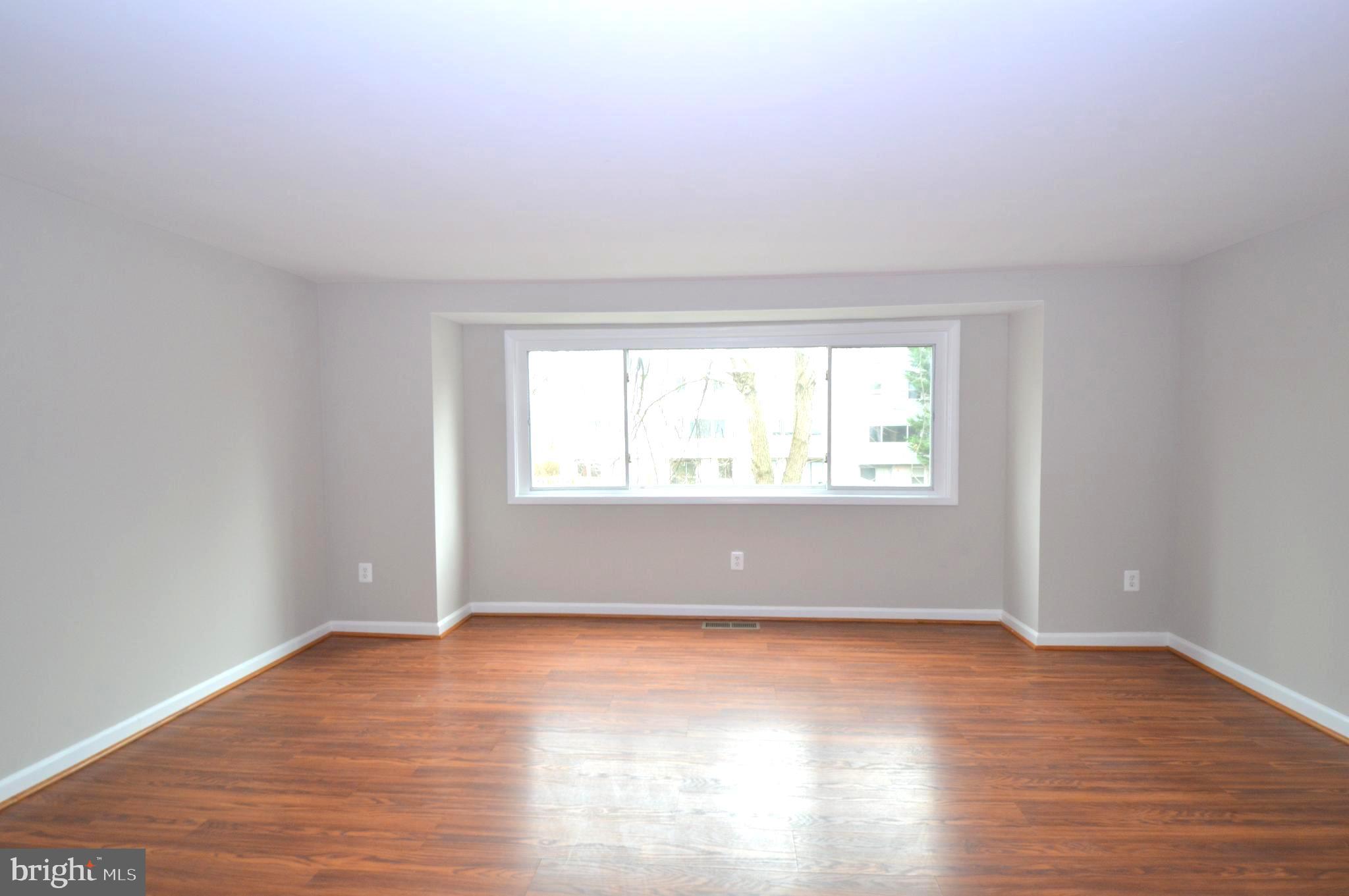 9410 Merryrest Road Columbia, MD 21045 - Photo 3 of 26 an empty room with wooden floor and windows