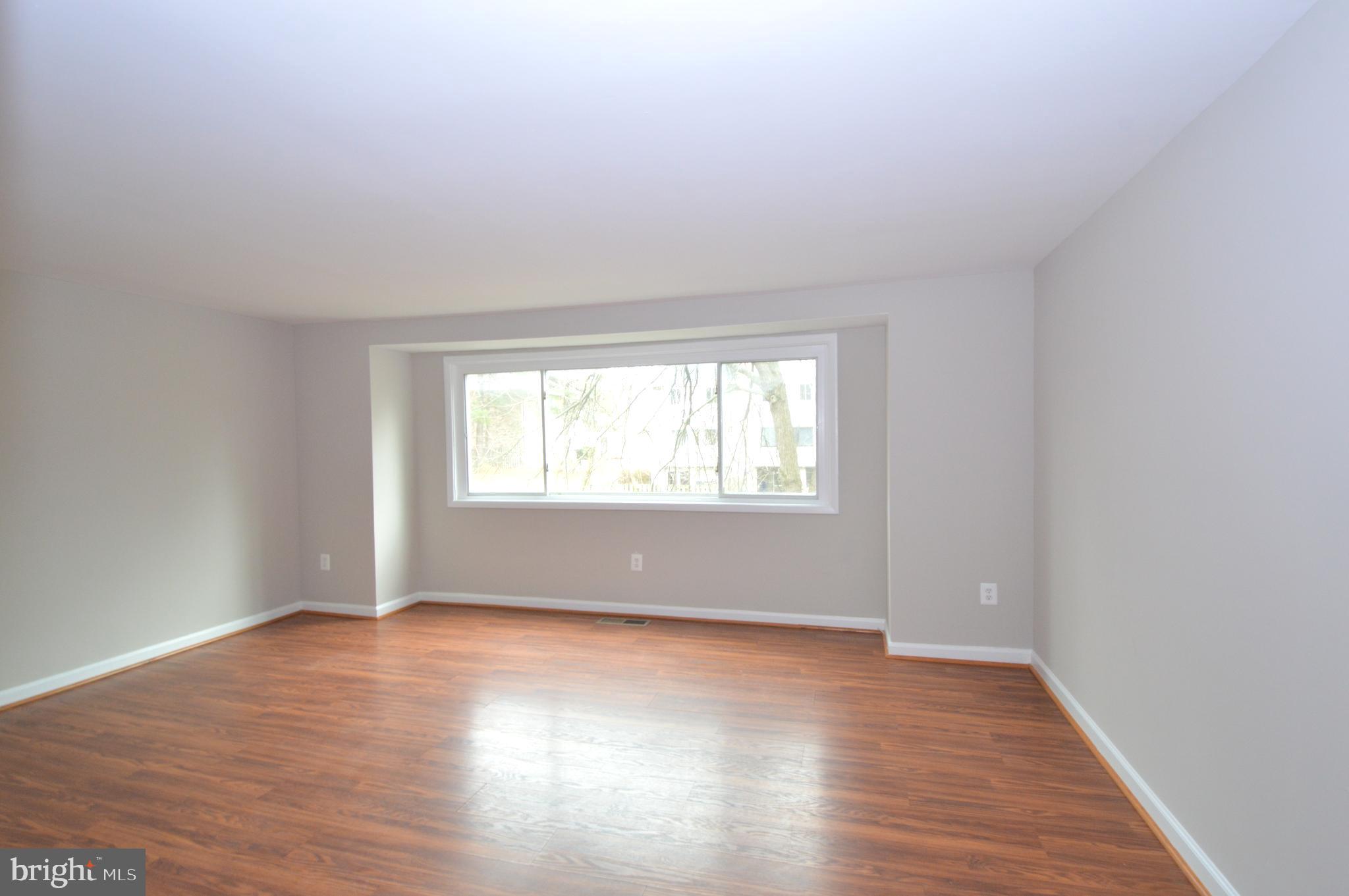 9410 Merryrest Road Columbia, MD 21045 - Photo 4 of 26 an empty room with wooden floor and windows